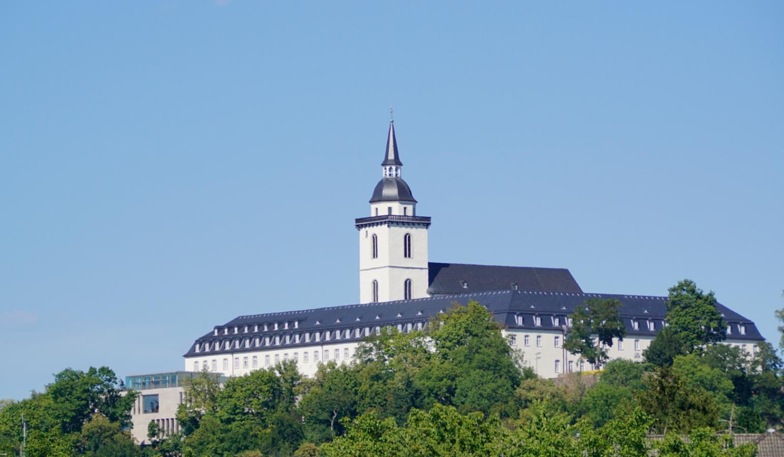 Die ehemalige Abtei Sankt MIchael - heute das Katholisch-Soziales Institut - vom Ufer des Flusses Sieg aus.